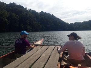 a man and a woman on a boat on a lake at 3 days jungle trekking adventure tour and camping in Munduk