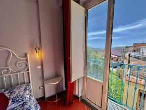 a bedroom with a bed and a large window at Taorminas Sun Central Boutique Guesthouse & Suites in Taormina