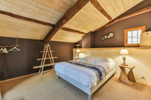 a bedroom with a bed and a wooden ceiling at Nature et partage - Jacuzzi - Wifi in Grand-Landes