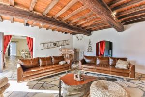 a living room with leather couches and a table at Nature et partage - Jacuzzi - Wifi in Grand-Landes +23 photos