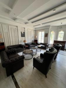 a large living room with black couches and tables at Vorano Boutique Hotel Islamabad in Islamabad