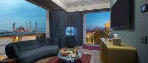 a living room with a couch and a large window at The Komana Binbirdirek in Istanbul