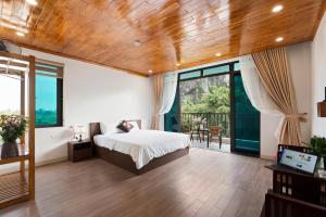 a bedroom with a bed and a large window at Maison Tam Cốc Homestay in Vũ Lâm
