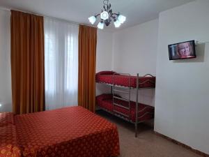 a bedroom with red beds and a window with a chandelier at Lucazione Turistica in Mestre