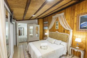 1 dormitorio con cama blanca y paredes de madera en Casa Rural Villa Mellizos, en Peñaflor 40 fotos más