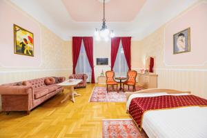 a bedroom with a bed and a couch and a table at Cotton House Budapest in Budapest