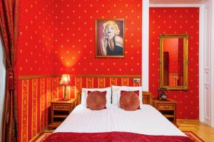 a bedroom with red walls with a bed and a mirror at Cotton House Budapest in Budapest +76 photos
