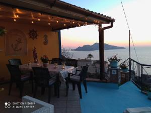 a table on a balcony with a view of the ocean at Casa Ancora in Massa Lubrense