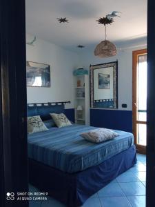 a bedroom with a bed with a blue comforter at Casa Ancora in Massa Lubrense