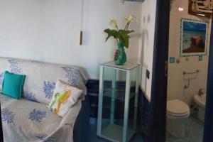 a living room with a couch and a vase with a plant at Casa Ancora in Massa Lubrense