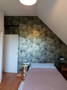 a bedroom with a bed in a room with a wall at Chambres d'hôtes, Le champ fleuri in La Châtre