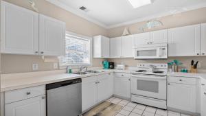 a white kitchen with white cabinets and a sink at 422 Cypress Bend Condo in North Myrtle Beach