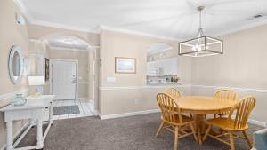 a kitchen and dining room with a table and chairs at 422 Cypress Bend Condo in North Myrtle Beach