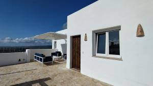 ein weißes Haus mit einer Terrasse mit Sonnenschirm in der Unterkunft Casa Anna in Facinas