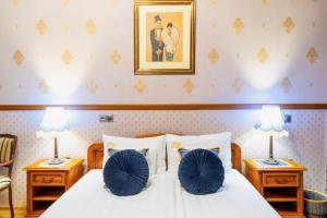 a bedroom with a bed with blue pillows on it at Cotton House Budapest in Budapest