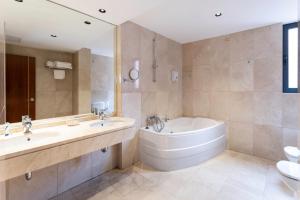 a bathroom with a tub and a sink and a bath tub at Hotel Doña Urraca in Zamora +54 photos