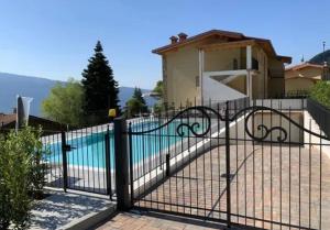 a gate with a pool in front of a house at Apartment Monti e Lago - Tignale in Tignale