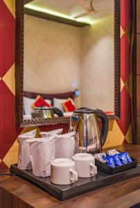 瓦拉纳西Shiv Rudraksh Resort, Near Assi Ghat的桌子上放着一个托盘，上面放着茶壶和一些包装袋。