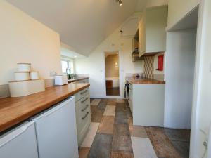 eine Küche mit weißen Schränken und einer Holzarbeitsplatte in der Unterkunft East View Cottage iow in Chalegreen + 23 Fotos