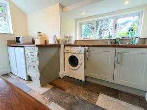 eine Küche mit Waschmaschine und Spüle in der Unterkunft East View Cottage iow in Chalegreen
