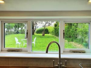 ein Küchenfenster mit Blick auf einen Hof in der Unterkunft East View Cottage iow in Chalegreen