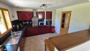 a kitchen with red cabinets and a counter top at Belle maison spacieuse proximité mer in Le Crotoy