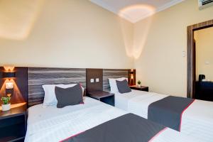 una camera d'albergo con due letti e una finestra di Collection O Pusat Kota Pekanbaru Near Rumah Sakit Prima Formerly King's Homestay a Pekanbaru