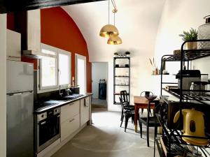 a kitchen with a table and a dining room at Gîtes ESCAPADE in Barjac