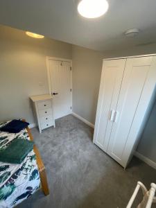 a bedroom with a bed and a dresser and a closet at Westbourne Alum Chine apartments in Bournemouth