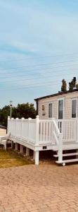 a house with a white porch and a white fence at Rockley Park 3 Bedrooms in Poole