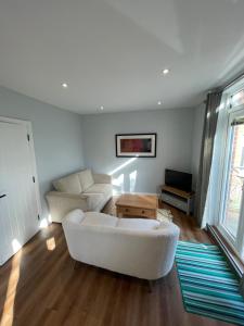 a living room with a white couch and a table at Westbourne Alum Chine apartments in Bournemouth