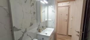 a bathroom with a white sink and a mirror at Victoria's Apartments in Néa Tríglia