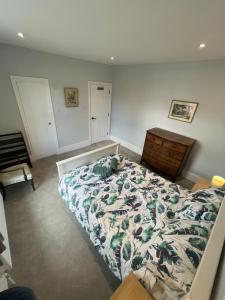 a bedroom with a bed and a wooden dresser at Westbourne Alum Chine apartments in Bournemouth +21 photos