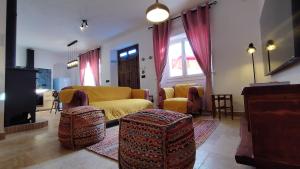 ein Wohnzimmer mit einem gelben Sofa und Stühlen in der Unterkunft Casa Anna in Facinas