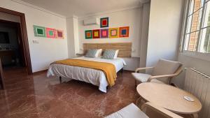 a bedroom with a bed and a table and chairs at Casa Frijol 20metres from the beach in Los Alcázares
