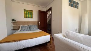 a bedroom with a bed and a couch at Casa Frijol 20metres from the beach in Los Alcázares
