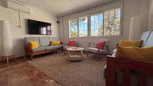 a living room with a couch and chairs and a tv at Casa Frijol 20metres from the beach in Los Alcázares