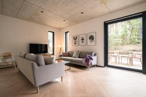 een woonkamer met een bank en een televisie bij Waldvilla Haus Gustav am Ostseestrand in Lubmin