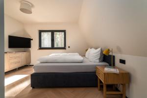 een slaapkamer met een groot bed en een televisie bij Waldvilla Haus Gustav am Ostseestrand in Lubmin