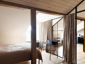 リエパーヤにあるKurshu Mansards - Modern Loftのベッドと机のある寝室