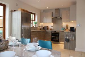 a kitchen with a table with chairs and a refrigerator at Minafon in Llanbedr