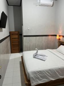 Ngurah Rai International AirportD nux House的一间卧室，床上有两条毛巾