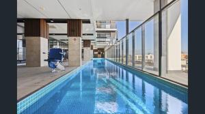 ein Pool in einem Gebäude mit einem WC in der Mitte in der Unterkunft CBD Resort with King Suite, Pool, Gym, Sauna, Cafe, Wifi, IGA in Adelaide