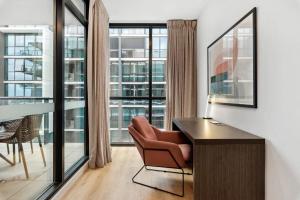 ein Wohnzimmer mit Schreibtisch und Stuhl in der Unterkunft CBD Resort with King Suite, Pool, Gym, Sauna, Cafe, Wifi, IGA in Adelaide