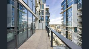 einen leeren Balkon eines Gebäudes mit Glasfenstern in der Unterkunft CBD Resort with King Suite, Pool, Gym, Sauna, Cafe, Wifi, IGA in Adelaide