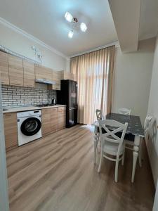 uma cozinha com uma mesa, um fogão, uma mesa e cadeiras em Sumqayıt Bulvar em Sumqayıt