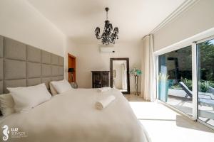 a bedroom with a white bed and a large window at 180 degree Ocean Views, Pure Paradise in Luz +21 photos