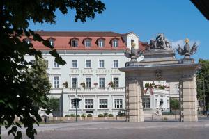 a large white building with a statue in front of it at Potsdam Hotel Am Jägertor in Potsdam