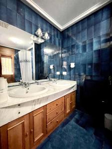 a bathroom with a sink and a large mirror at Home Campoamor in Orihuela Costa