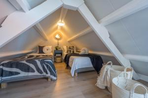 a attic bedroom with two beds and a roof at De Grote Stern in Groet